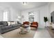 Relaxing living room with gray sofa and orange accent chairs at 4241 Paragraph Dr, Kissimmee, FL 34746