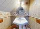 Well-lit bathroom featuring a pedestal sink and tile at 6353 River Rd, New Smyrna Beach, FL 32169