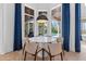 Bright breakfast nook with white round table and blue curtains at 9343 Tibet Pointe Cir, Windermere, FL 34786