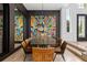 Modern dining room with a large black table and colorful artwork at 9343 Tibet Pointe Cir, Windermere, FL 34786