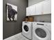 Bright laundry room with Whirlpool washer and dryer and white cabinets at 14279 Crest Palm Ave, Windermere, FL 34786
