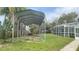 Backyard with metal carport and screened enclosure at 1625 Normandy Way, Leesburg, FL 34748