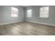 Bright bedroom with three windows and wood-look floors at 1625 Normandy Way, Leesburg, FL 34748