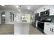 Modern kitchen with stainless steel appliances, white cabinets, and a large island at 1625 Normandy Way, Leesburg, FL 34748
