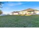 Large grassy backyard with a covered patio and white vinyl fence at 2325 Crossandra St, Mascotte, FL 34753