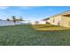 Spacious backyard featuring a large grassy area and a home with covered patio at 2325 Crossandra St, Mascotte, FL 34753