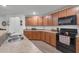 Modern kitchen with wood cabinets, stainless steel appliances, and granite countertops at 2325 Crossandra St, Mascotte, FL 34753