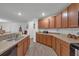 Modern kitchen with wood cabinets, stainless steel appliances, and granite countertops at 2325 Crossandra St, Mascotte, FL 34753