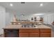 Modern kitchen island with double sink, dishwasher, and view into the living room at 2325 Crossandra St, Mascotte, FL 34753