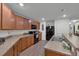 Modern kitchen with wood cabinets, stainless steel appliances, and granite countertops at 2325 Crossandra St, Mascotte, FL 34753