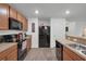 Modern kitchen with wood cabinets, stainless steel appliances, and granite countertops at 2325 Crossandra St, Mascotte, FL 34753