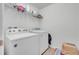 Functional laundry room with washer, dryer, and shelving at 2325 Crossandra St, Mascotte, FL 34753
