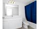 Modern bathroom with white vanity and blue shower curtain at 2362 Lancashire St, Davenport, FL 33896