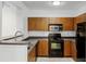 Modern kitchen with dark wood cabinets, black appliances, and granite countertops at 304 E South St # 2022, Orlando, FL 32801