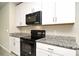 Modern kitchen with granite countertops and black appliances at 3466 Monaco Ln, Davenport, FL 33897