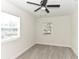 Spacious bedroom with two windows, ceiling fan, and gray wood-look flooring at 550 N Ridgewood Ave, Daytona Beach, FL 32114