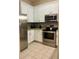 Bright white kitchen with stainless steel appliances, and neutral tiled backsplash and floors at 605 Rum Run # 605, Davenport, FL 33837