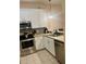 Compact kitchen with white shaker cabinets, stainless steel appliances, and tiled floor at 605 Rum Run # 605, Davenport, FL 33837