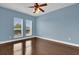Light blue bedroom with hardwood floors and windows at 7500 Toscana Blvd # 333, Orlando, FL 32819