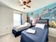 Twin bedroom with ocean mural and ceiling fan at 826 Paradise Dr, Davenport, FL 33897
