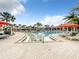 Large resort-style community pool with lounge chairs, umbrellas, and a zero-entry at 826 Paradise Dr, Davenport, FL 33897