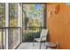 Screened balcony with a seating area overlooking trees at 9051 Treasure Trove Ln # 102, Kissimmee, FL 34747