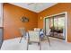 Screened-in balcony with a dining table, chairs, and lush views at 9051 Treasure Trove Ln # 102, Kissimmee, FL 34747