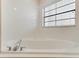 Bathroom features a corner soaking tub with tile surround and window at 9051 Treasure Trove Ln # 102, Kissimmee, FL 34747