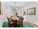 Dining room with a glass-top table, wicker chairs, and a view of the adjacent living space at 9051 Treasure Trove Ln # 102, Kissimmee, FL 34747