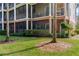 Ground-level view of the building with screened balconies and lush landscaping at 9051 Treasure Trove Ln # 102, Kissimmee, FL 34747