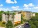 View of the condo building's exterior, emphasizing its multi-story structure, landscaping, and parking at 9051 Treasure Trove Ln # 102, Kissimmee, FL 34747