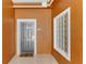 Condo entrance with a gray door, decorative glass block window, and welcome mat at 9051 Treasure Trove Ln # 102, Kissimmee, FL 34747