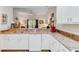 Open concept kitchen with white cabinets, granite counters, and view of the living room at 9051 Treasure Trove Ln # 102, Kissimmee, FL 34747