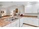 White kitchen with double sink, granite countertops, and view of living space at 9051 Treasure Trove Ln # 102, Kissimmee, FL 34747