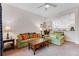 Living room with green couches, ceiling fan, and view into the kitchen at 9051 Treasure Trove Ln # 102, Kissimmee, FL 34747