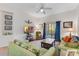 Living room featuring green couches, ceiling fan, and access to a private balcony or patio at 9051 Treasure Trove Ln # 102, Kissimmee, FL 34747