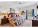 Main bedroom with ceiling fan, windows with blue curtains, and carpeted floors at 9051 Treasure Trove Ln # 102, Kissimmee, FL 34747