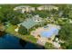 Aerial view of the community pool area with lounge chairs and a clubhouse at 9051 Treasure Trove Ln # 102, Kissimmee, FL 34747