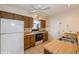 Kitchen with wood cabinets, a white refrigerator, an electric range, and a double sink at 10656 Whitman Cir, Orlando, FL 32821