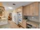 Kitchen equipped with white appliances, light wood cabinets, and a counter area at 1130 Jacaranda Ave, Daytona Beach, FL 32118