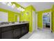 Bright bathroom with double vanity, dark wood cabinets, and lime green walls at 1528 Mulligan Blvd, Davenport, FL 33896