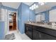 Blue bathroom with double vanity, granite countertop, and walk-in shower at 1528 Mulligan Blvd, Davenport, FL 33896
