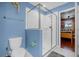 Clean and bright bathroom with glass shower, toilet, and blue accent wall at 1528 Mulligan Blvd, Davenport, FL 33896