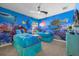Under the sea themed bedroom with two twin beds and a vibrant ocean mural at 1528 Mulligan Blvd, Davenport, FL 33896