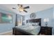 Light blue bedroom featuring a king-size bed, ceiling fan, and bedside tables at 1528 Mulligan Blvd, Davenport, FL 33896