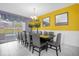 Elegant dining room featuring a large table, ample seating, and a bright yellow accent wall at 1528 Mulligan Blvd, Davenport, FL 33896