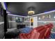 Home cinema room featuring red leather reclining chairs, large screen, and themed decor at 1528 Mulligan Blvd, Davenport, FL 33896