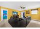 Living room with leather sectional sofa, entertainment center, and bright yellow walls at 1528 Mulligan Blvd, Davenport, FL 33896
