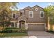 Beautiful two-story home with a stone and stucco facade, attached garage, and landscaped front yard at 1530 Moon Valley Dr, Davenport, FL 33896