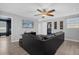 Living area with a black sectional sofa, ceiling fan, and wood-look flooring at 1530 Moon Valley Dr, Davenport, FL 33896